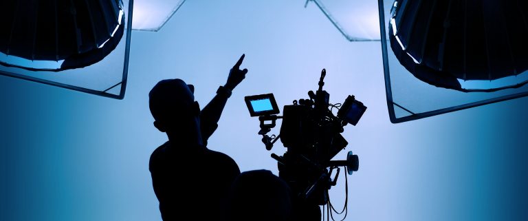 Producción audiovisual en un estudio de grabación con equipo de iluminación y cámaras.