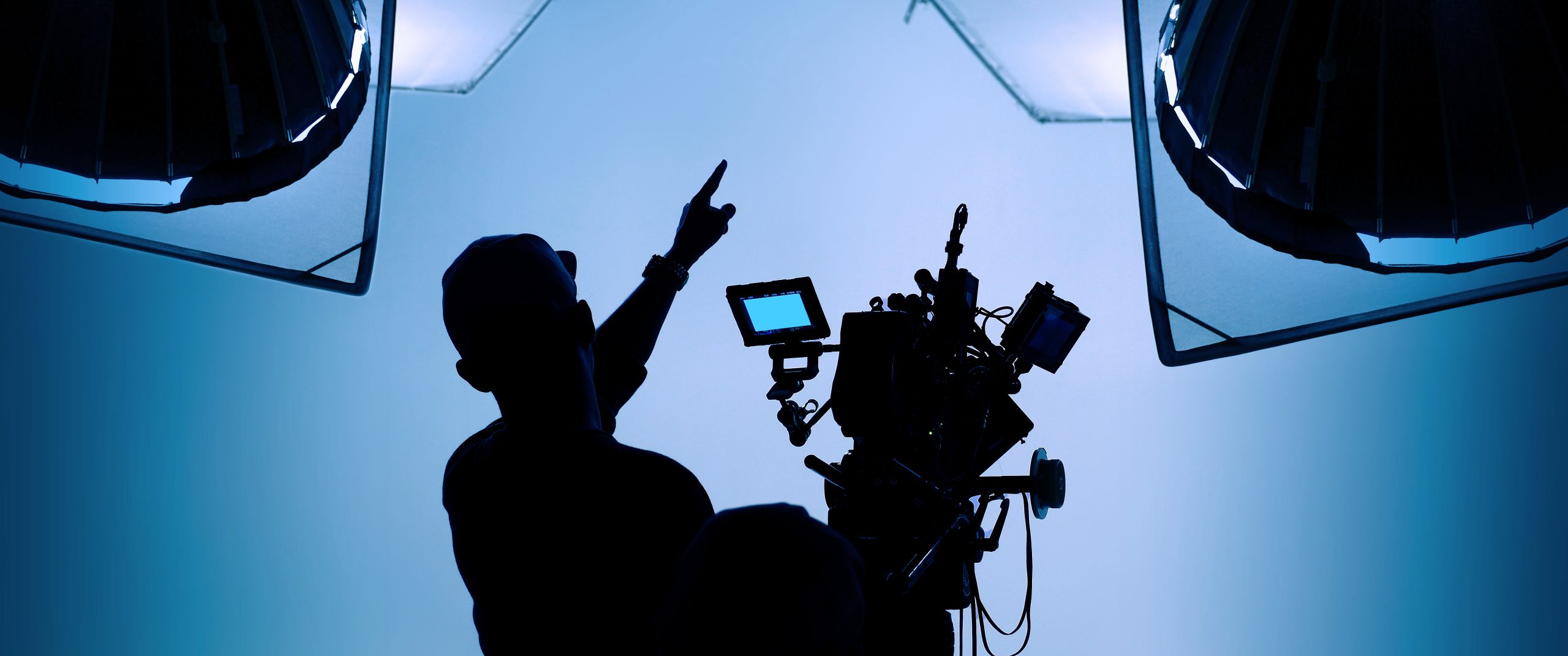Producción audiovisual en un estudio de grabación con equipo de iluminación y cámaras.